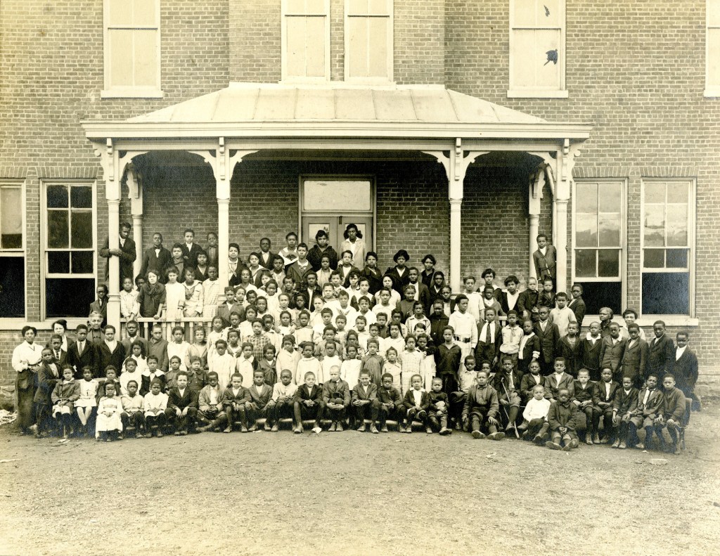Group of Calfee Training School teachers and students gathered outside the Calfee Training School building.