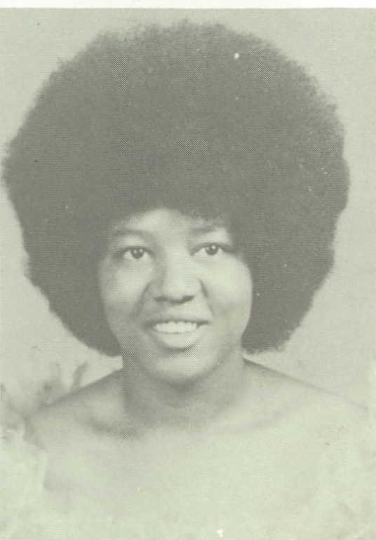 old photo of woman smiling at the camera with afro