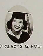 Black and white Graduation photo of Gladys Holt in her cap and gown smiling at camera.