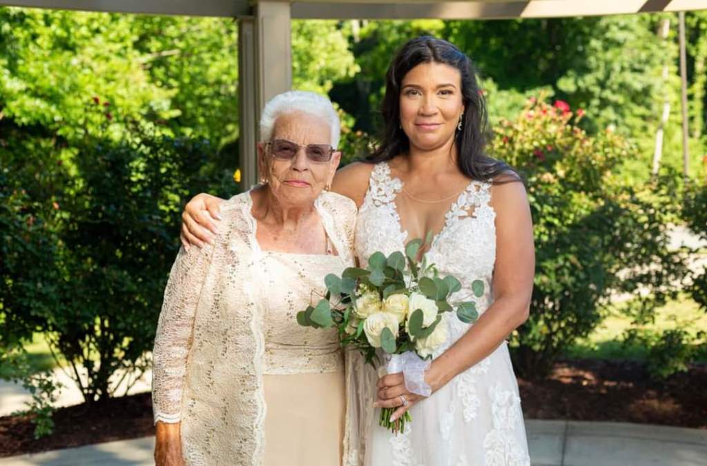 woman in a wedding dress posing for a photo with an elderly woman