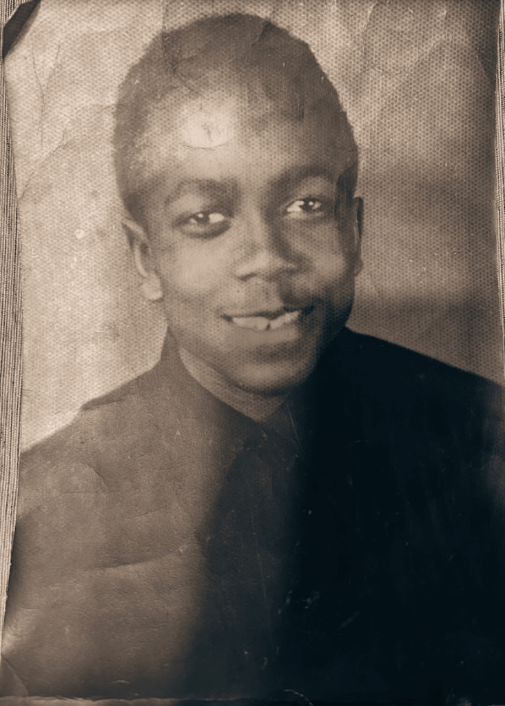 Black and white portrait of a young man smiling at the camera
