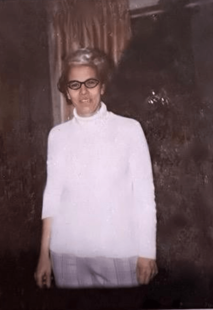 a slightly older woman standing and posing for a photo