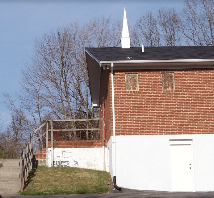 Side view of church with brick exterior and stairs leading up to it