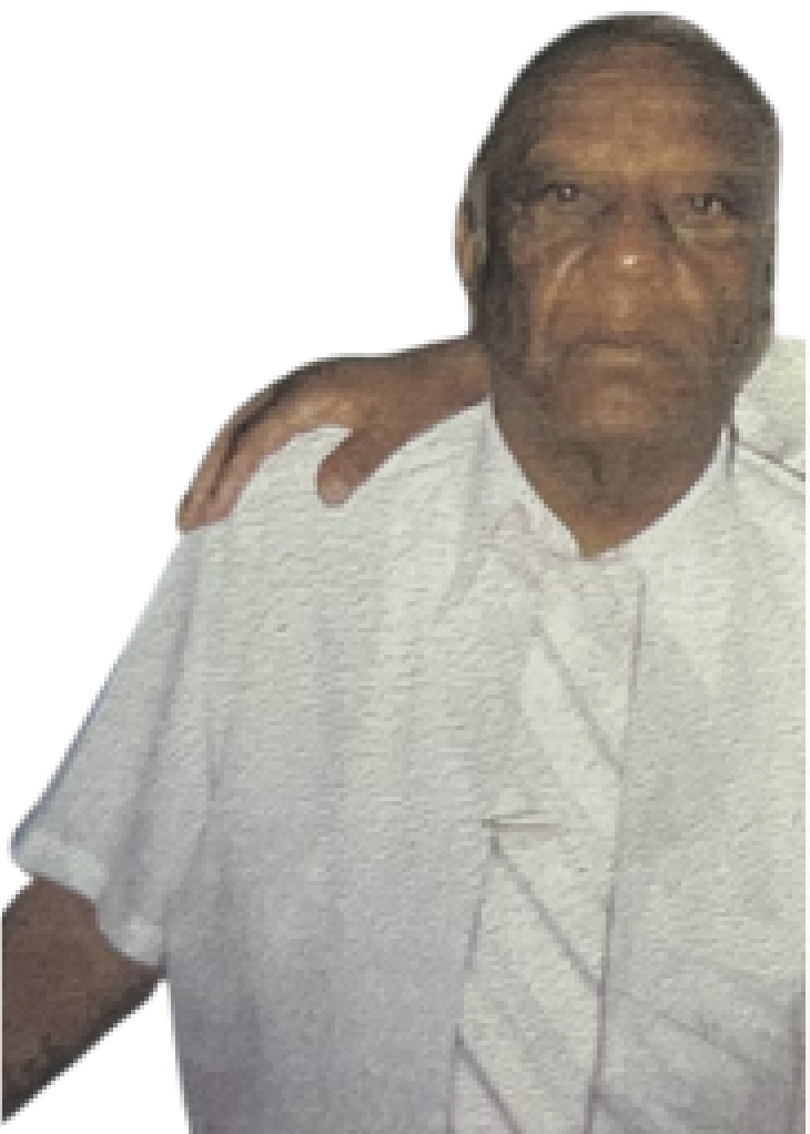 Older man wearing a white shirt and white tie. He has a blank expression and is looking directly ahead.