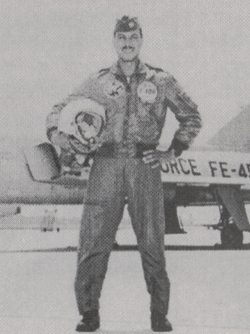 Black and white photo of a African American male in an air force uniform in front of a plane