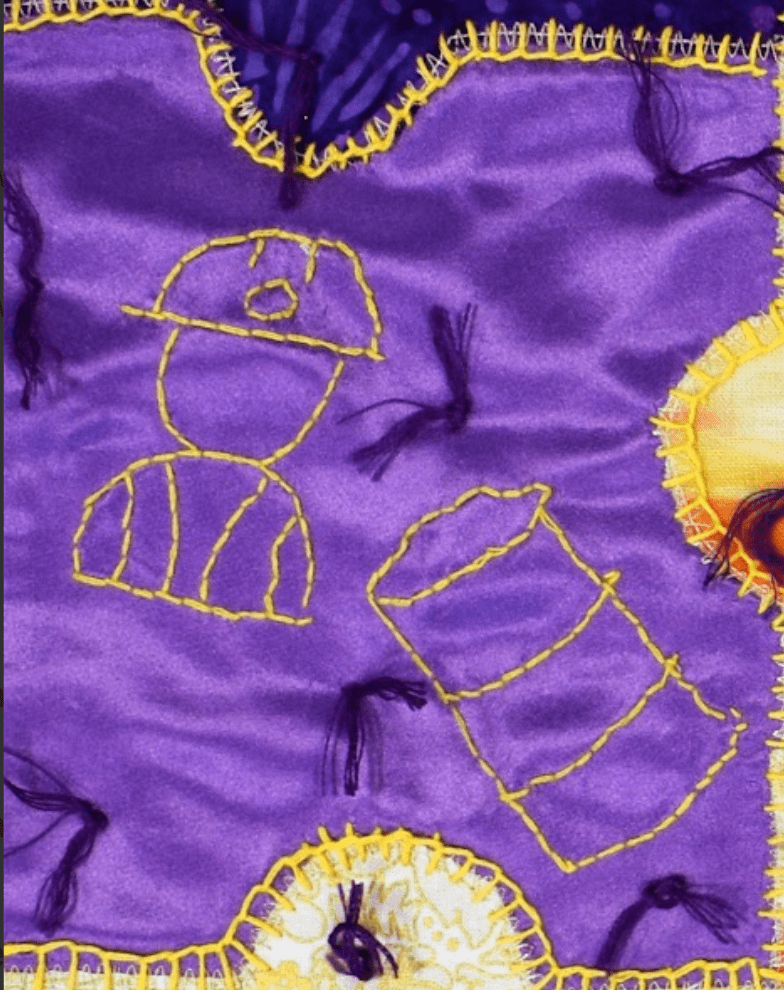 Up close image of construction symbols that are stitched onto purple silk fabric in the shape of a puzzle piece. The symbol on the left is of a construction worker an d the symbol on the right is a barrel. 